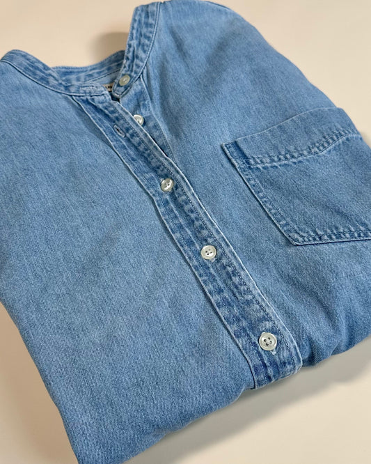 Folded blue denim shirt on a white background